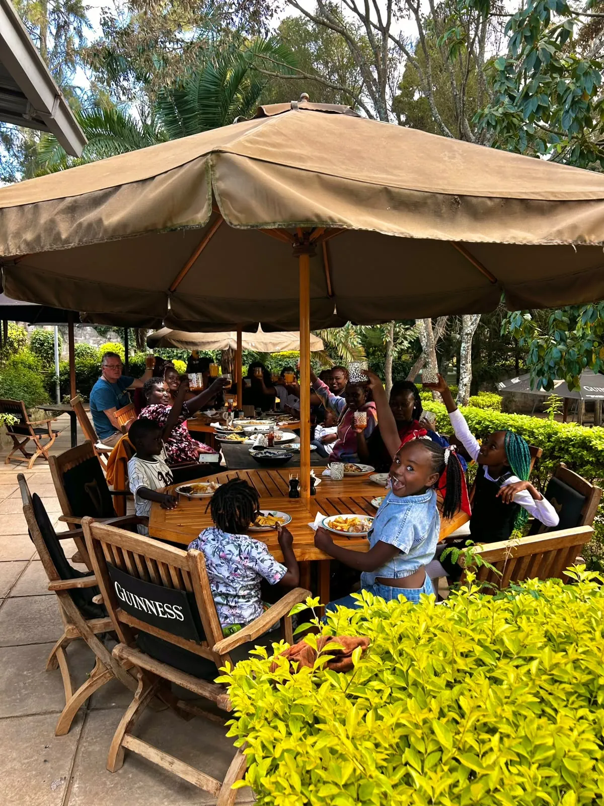 Family and friends enjoying an outdoor meal under umbrellas
